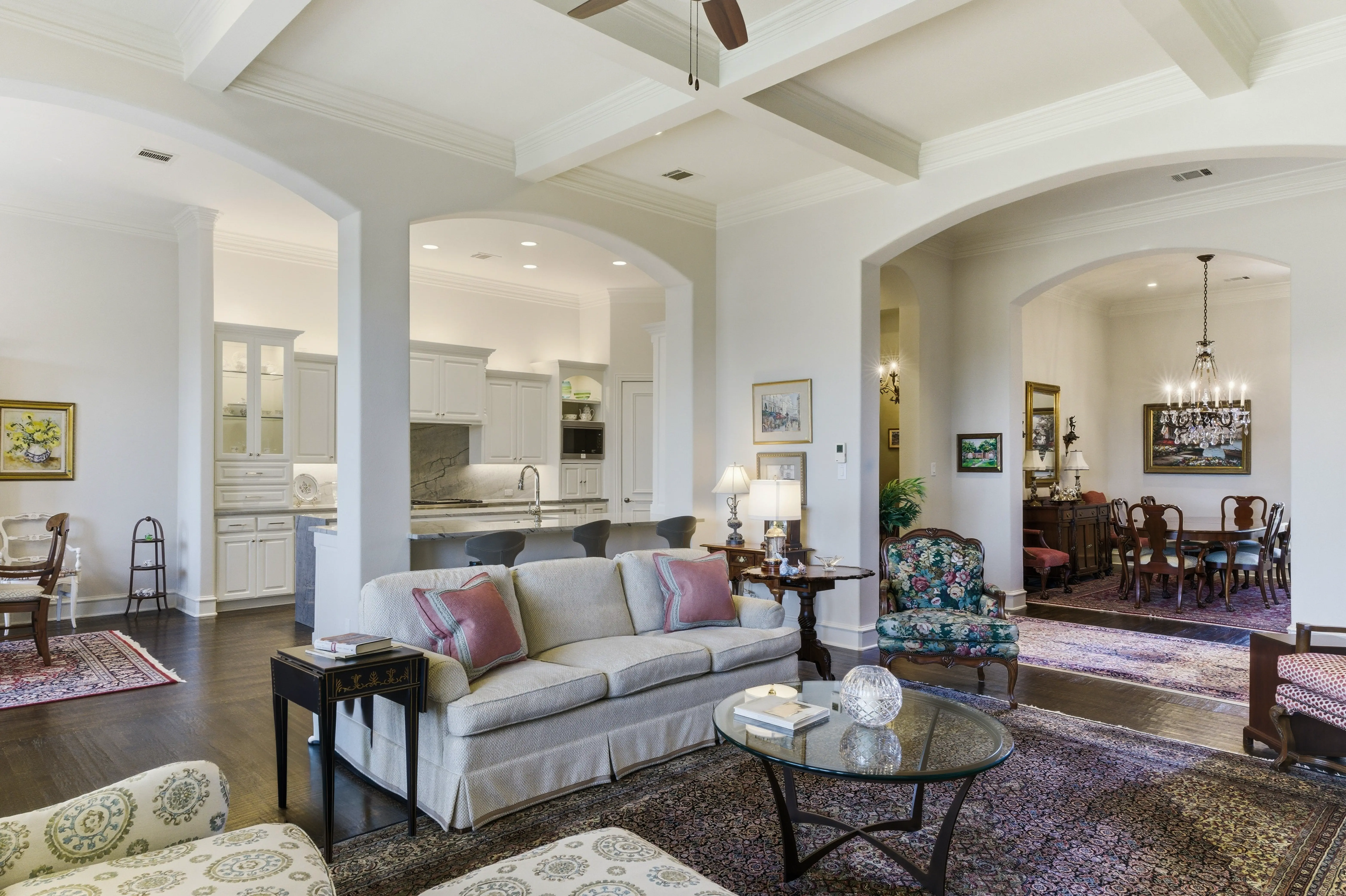 Open concept living and dining area with soaring ceilings and architectural columns